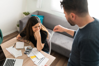 Stressed couple doing tradie bookkeeping at home before EOFY