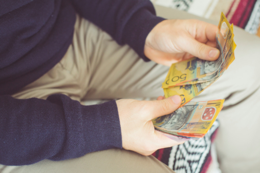 A stressed tradie counting money at the end of the financial year