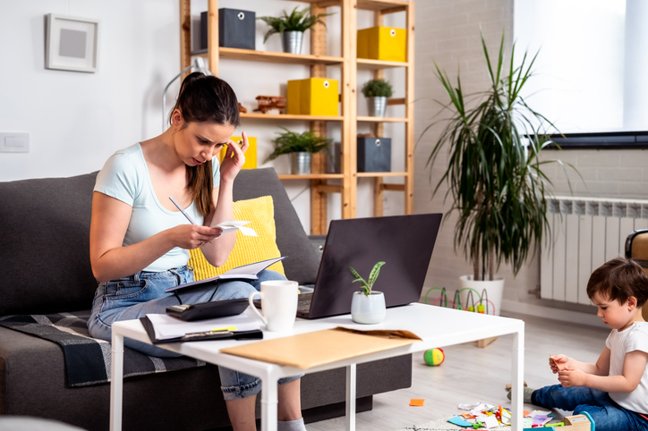 Partner of small trade business owner sorting invoices and paperwork while implementing bookkeeping systems