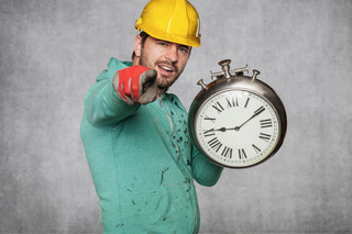 Tradie in a hard hat holding a large clock, symbolising time savings for busy tradies